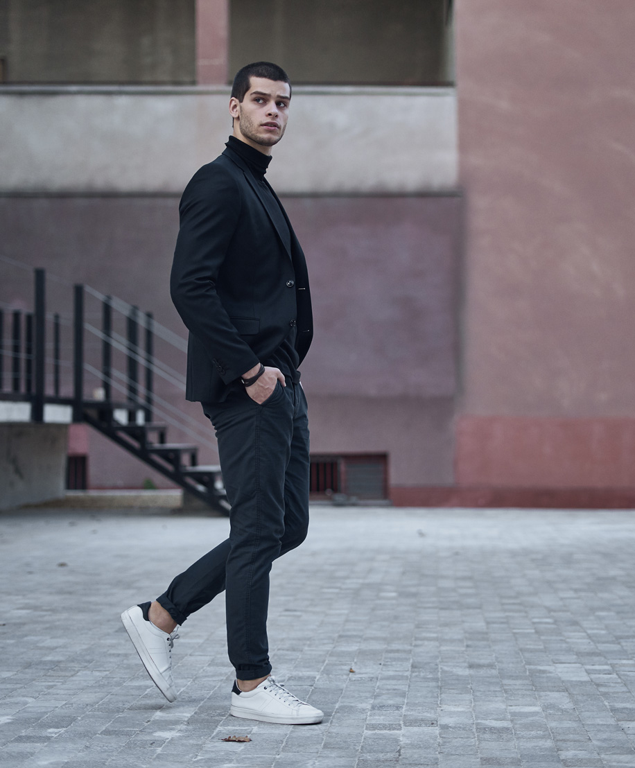 Man in all black with white sneakers walking on street - Artas iX Robotic in NYC