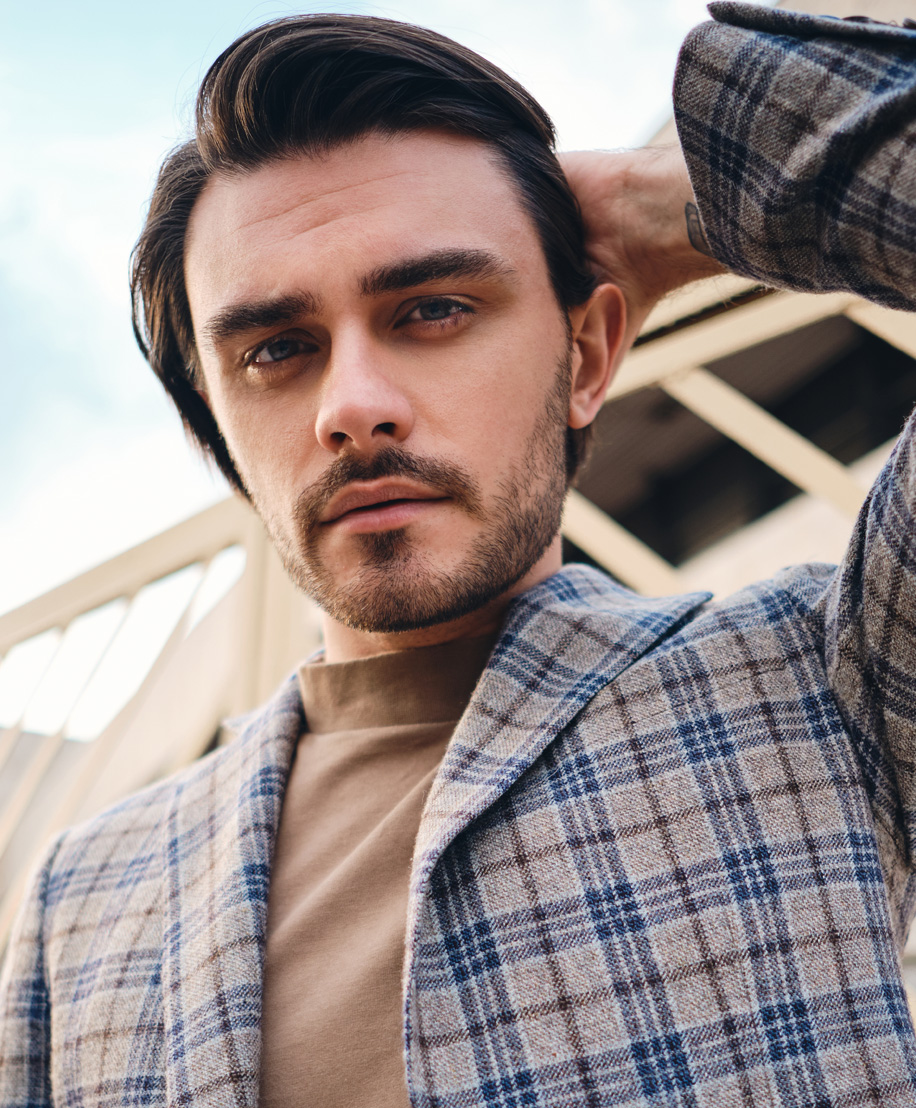 man in plaid suit with hand behind his head - FUT hair transplant in NYC