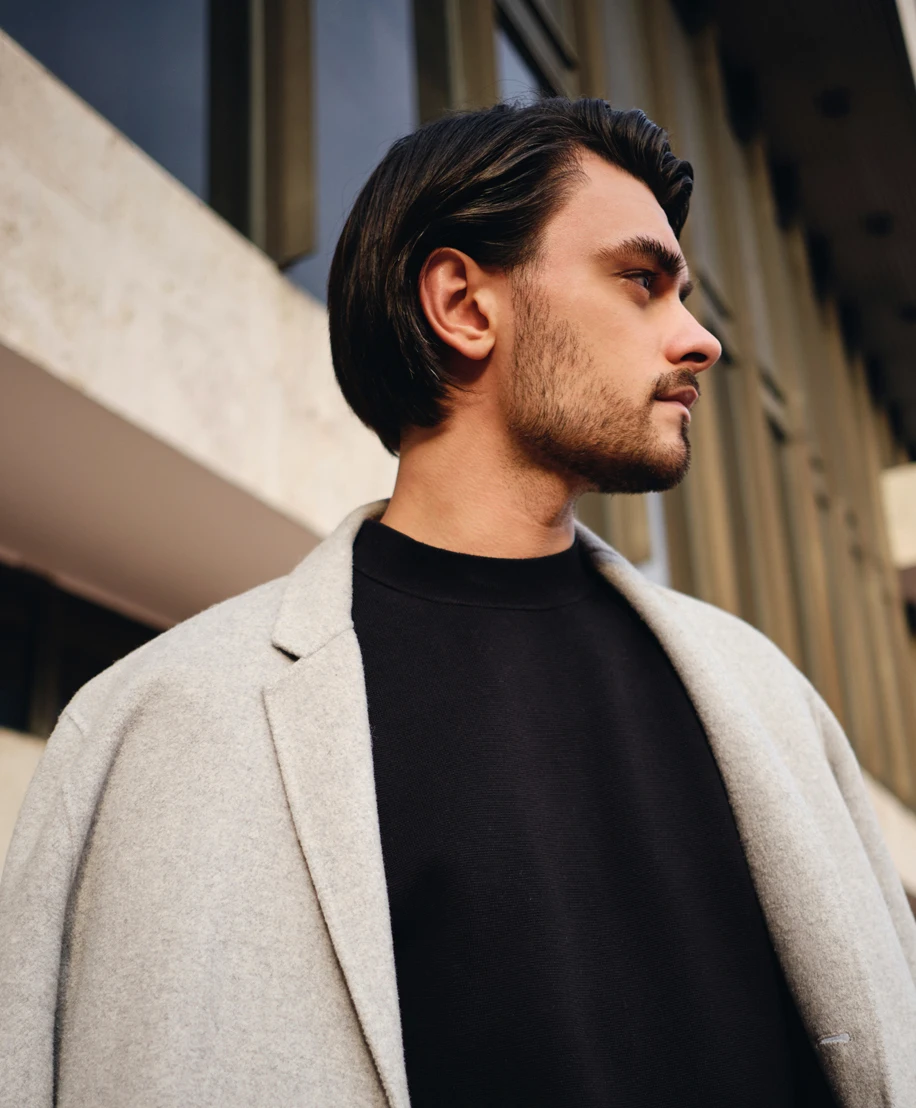 Male model in profile with a full head of hair and beard - Hair Transplant in NYC