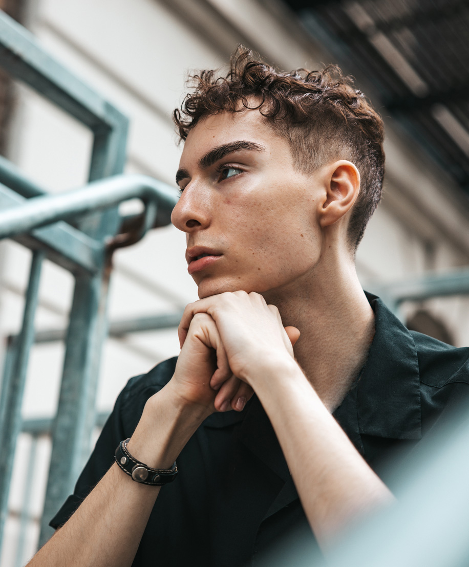 man with hands folded under chin - understanding hair loss in NYC